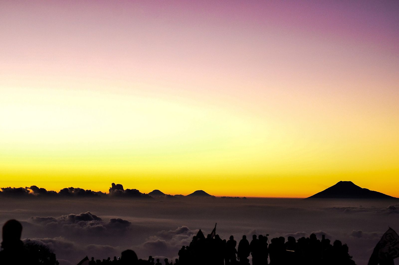 Orange sunrise above a sea of clouds seen from Ciremai's peak